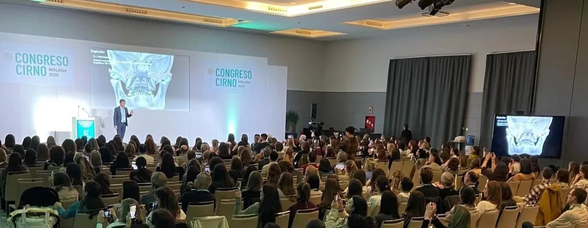 El Dr. Javier Plaza como ponente en el Congreso CIRNO Málaga 2026, con una radiografía proyectada en pantalla ante un auditorio lleno